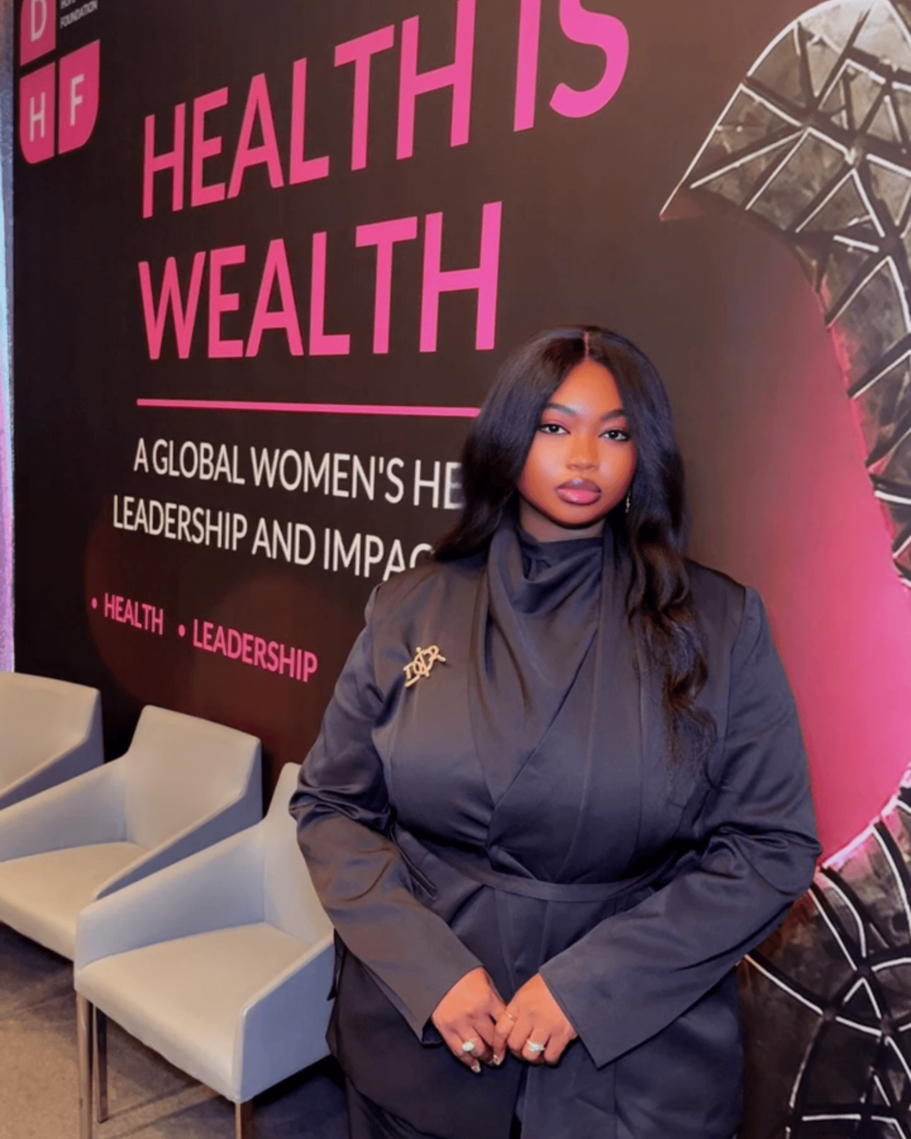 An attendee in a dark suit stands before the Health Is Wealth banner at the Dorothy’s Hope Foundation forum.