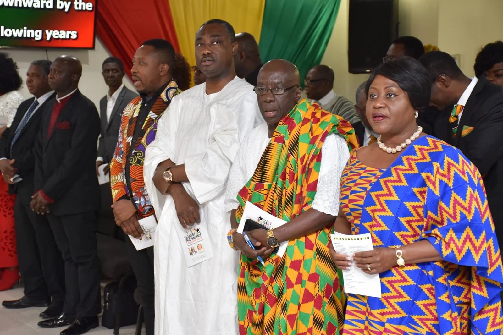 People standing together in Ghanaian cloth at a community gathering.