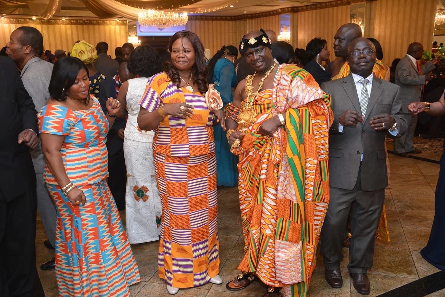 People standing together indoors in colorful Ghanaian cloth.
